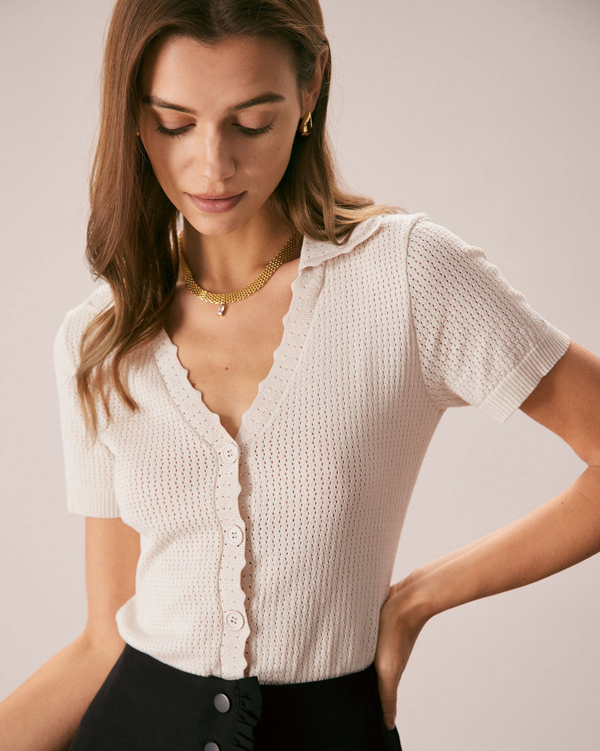 La camiseta de punto con cuello en V y botones en color nude